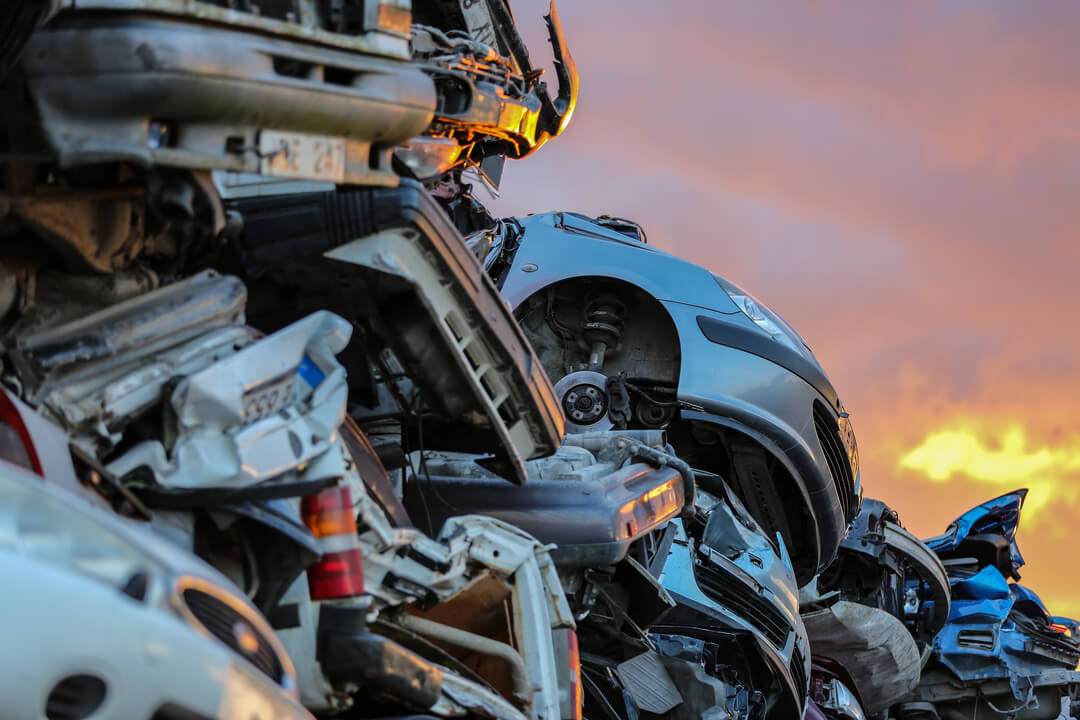 Hög med bilar och bildelar som skrotats.