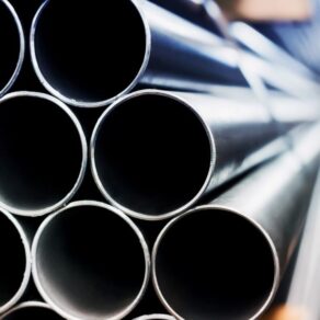 Närbild på staplade stålrör med öppna ändar.