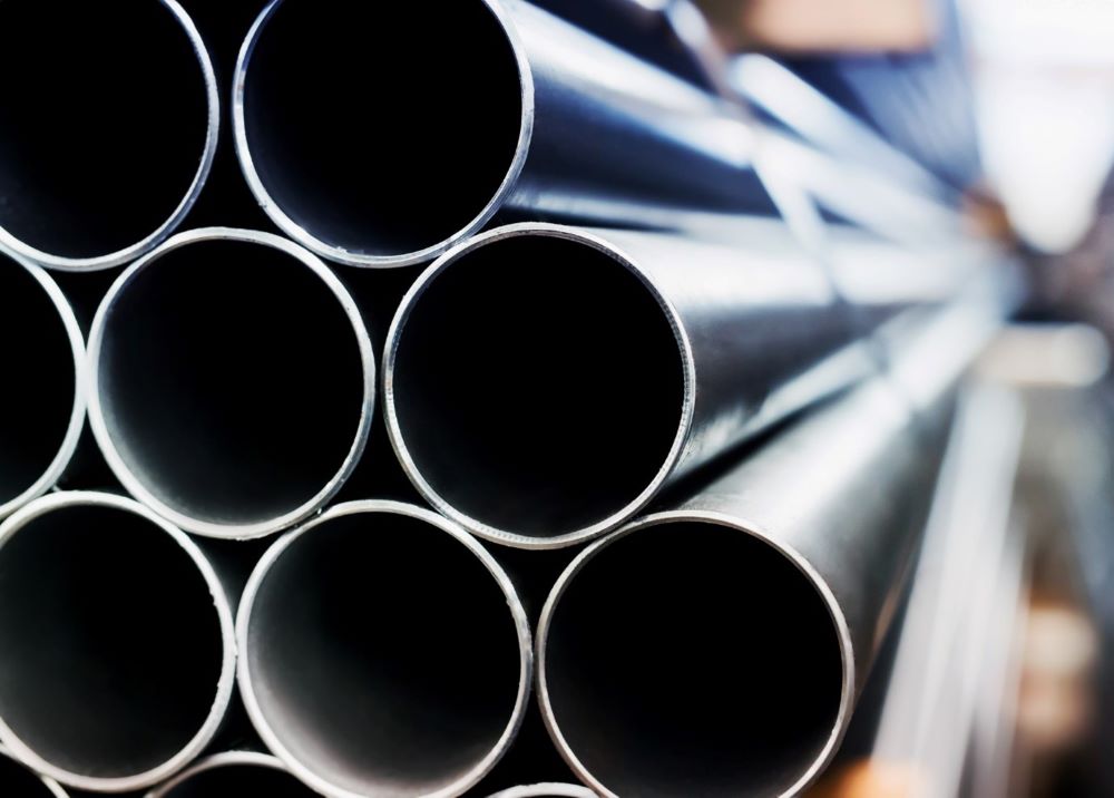 Närbild på staplade stålrör med öppna ändar.
