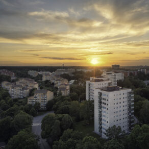 Flygfoto över flerfamiljshus i Bergshamra, Solna kommun, vid solnedgång.